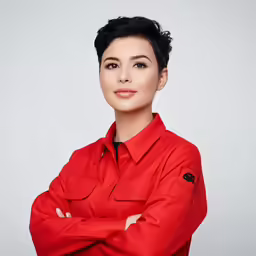 a woman in a red shirt with her arms crossed