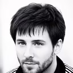a man wearing a striped shirt looking into the camera