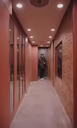 an empty corridor with a person in the mirror