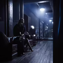 a woman sitting on a couch in a dimly lit room