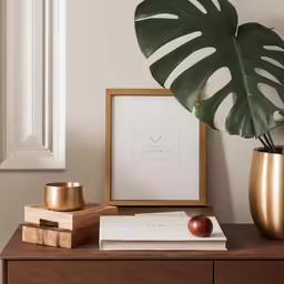a table with a plant and books next to a picture