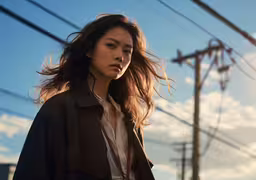 the woman is walking down the street with long hair,an asian woman walking through the city while holding her hair in her hand