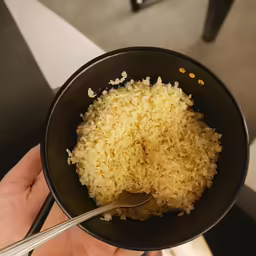 rice and a spoon in a black bowl
