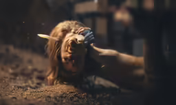 a woman lying on the ground in the dirt