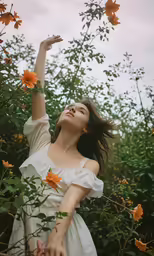 a woman is reaching up to the sky with her arm