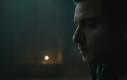 a person staring into a distance in a dark place