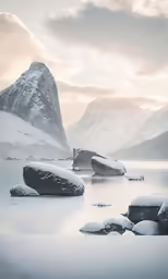 a small snow covered lake next to a tall mountain