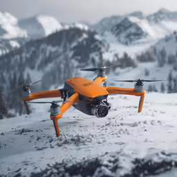 an orange rc quadcopter flying in the mountains