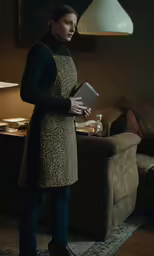 a young woman is standing in the dark with a book