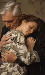 a woman and man hug each other while they are dressed up