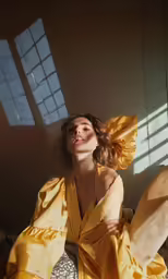 a woman in a yellow dress poses for a picture