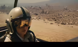 the boy with the helmet is flying on a plane