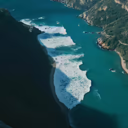 the view from an airplane showing the blue water and white foamy waves