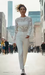 a woman wearing all white walking in the street