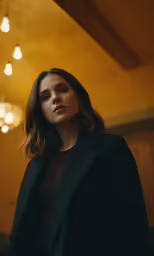 a woman standing in the room with a dark coat