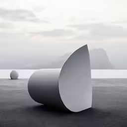 two white circular sculptures on black sand near the water