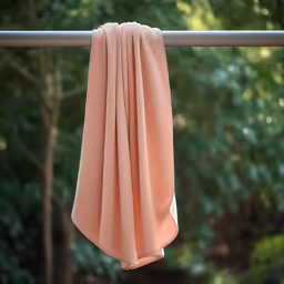 the top portion of a tan shirt draped by a window