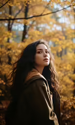 a woman with long hair standing in the woods