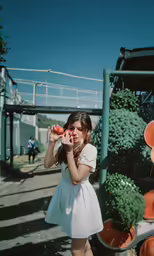 a young woman is drinking from a bowl