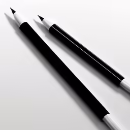 a pen laying next to a smaller one on top of a table