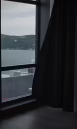 window with closed drapes overlooking the water