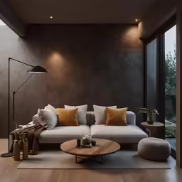 a well lit room with a white couch and many cushions