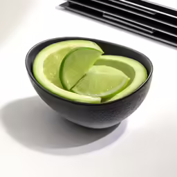 sliced limes in a bowl in front of windows