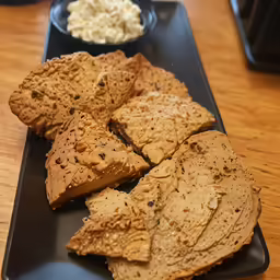 a plate topped with crackers next to a bowl
