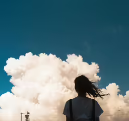 a man that is standing up with his hair blowing