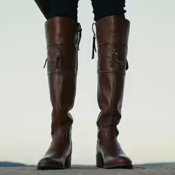 a pair of legs wearing brown leather shoes