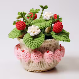 the potted plant is crocheted in the shape of flowers,a green leafy plant in a crochet pot