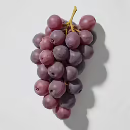 bunch of red grapes placed on a white surface