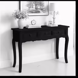 there is a small console table on the floor with a vase
