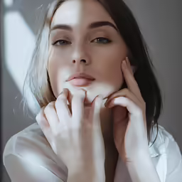 a woman posing with her hands on her face