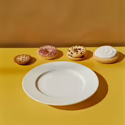 a plate is shown with two pastries and a cupcake,a plate with a doughnut on top and another one with chocolate sprinkles on it