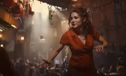 a woman in a red dress is dancing near a crowd