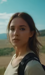young woman with shoulder bag outdoors in open countryside