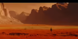 a lone person walking through the yellow field near huge rocks