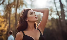 beautiful woman posing outdoors in a bra in a black dress
