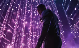 a man in a suit stands by a giant purple background