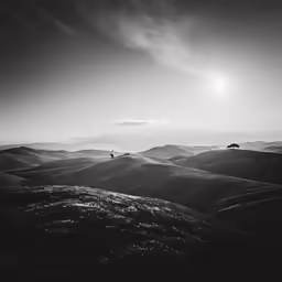 a bird flies through the clouds above hills