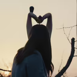 a women holding two birds above her head