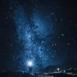 two people with flashlight standing on mountain at night