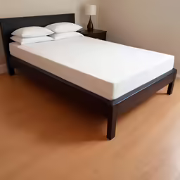a closeup of a bed with some pillows on it