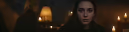 a woman with long hair standing in front of candles