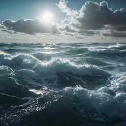 sun shining through clouds over waves on a body of water