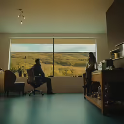 two people sitting on a chair watching out the window
