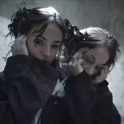 two girls with one girl talking on their cell phones
