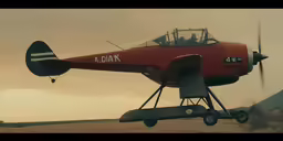 a plane flying over a dirt field with a person sitting on it