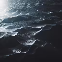 a close up of water on the ocean with a light shining over it